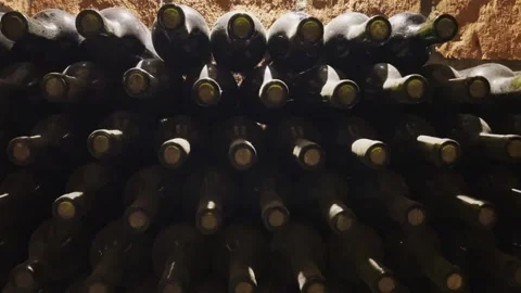 Rows of exclusive wine bottles stacked in a dark wine cellar. Winemaking concept Video stock 302721242