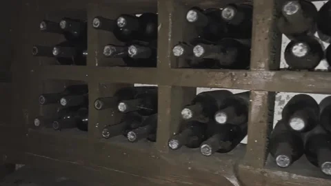 Rows of exclusive wine bottles stacked in a dark wine cellar. Winemaking concept Stock-Footage 302721273