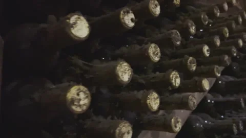 Rows of exclusive wine bottles stacked in a dark wine cellar. Winemaking concept Stock-Footage 302721360