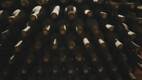 Rows of exclusive wine bottles stacked in a dark wine cellar. Winemaking concept Stock-Footage 303359230