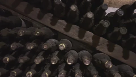 Rows of exclusive wine bottles stacked in a dark wine cellar. Winemaking concept Stock-Footage 303359379