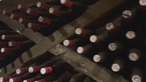 Rows of exclusive wine bottles stacked in a dark wine cellar. Winemaking concept Stock-Footage 303359563