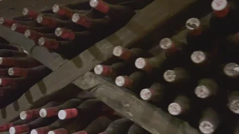 Rows of exclusive wine bottles stacked in a dark wine cellar. Winemaking concept Stock-Footage 305262771
