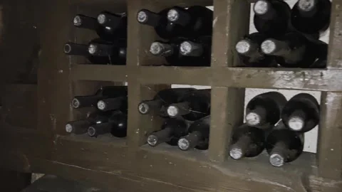 Rows of exclusive wine bottles stacked in a dark wine cellar. Winemaking concept Stock-Footage 306017759