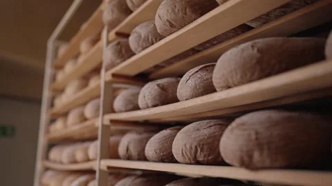 Rows of fresh bread loaves cooling on bakery shelves Stock Footage 334939056