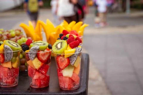 Rows of fresh cut fruit in plastic cups at urban street vendor stand Stock Photos