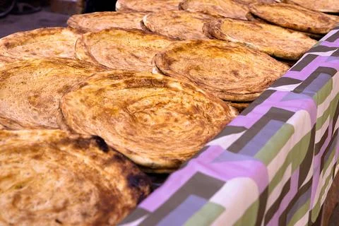 Rows of freshly baked traditional flatbread displayed at a bazaar in Bukhar.. Stock Photos