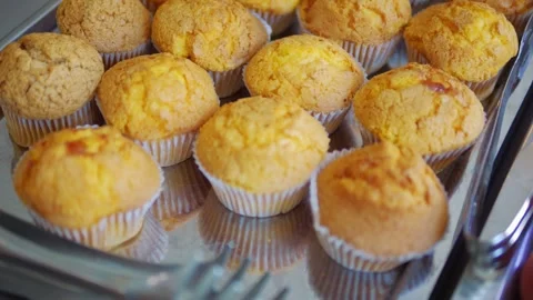 Rows of freshly baked vanilla muffins on display at a bakery in 4k slow mot.. Video stock 267682710