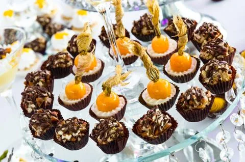 Rows of freshly made truffles with walnuts and Aguaymanto with sweets in a Фото