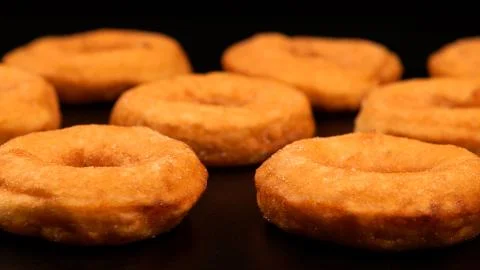 Rows of fried doughnuts on the black table Stock Photos