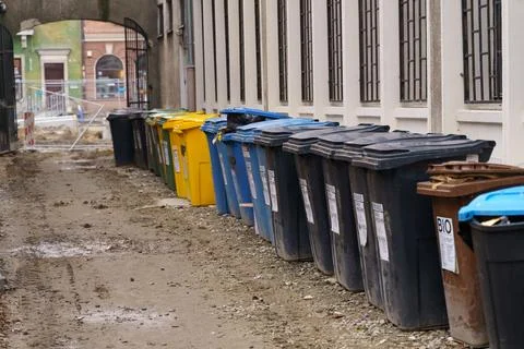 Rows of garbage cans of different colors in an alley in the city center, ne.. Stock Photos