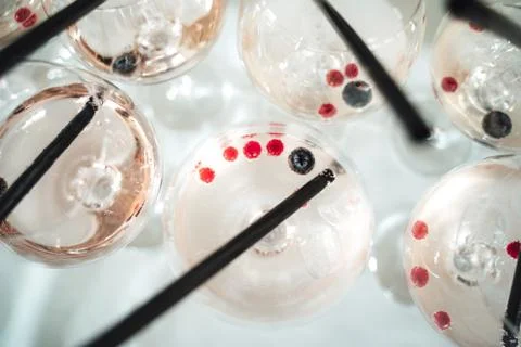 Rows of glasses with light pink beverage on buffet table top view. Close up of Stock Photos