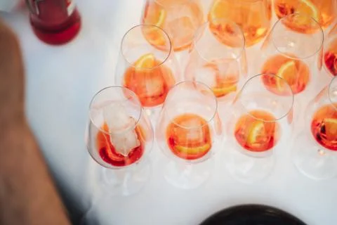 Rows of glasses with orange drink with slice of fresh orange and ice cubes on Stock Photos