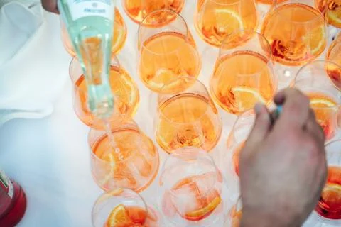 Rows of glasses with orange drink with slice of fresh orange on buffet table Stock Photos