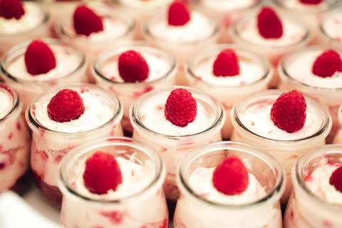Rows of glasses with raspberry sweet dessert on festive table closeup Stock Photos