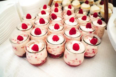 Rows of glasses with raspberry sweet dessert on festive table. Celebration Stock Photos