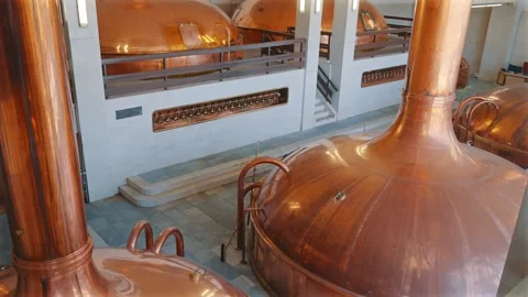 Rows of gleaming copper brewing vessels in a grand historic brewhouse interior Stock Footage 345853046