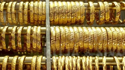 Rows of gold bracelets and rings in a display case Stock Footage 334950496
