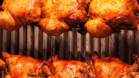Rows of golden brown whole roasted chickens slowly rotate on a spit in a ro.. 스톡 동영상 333031754