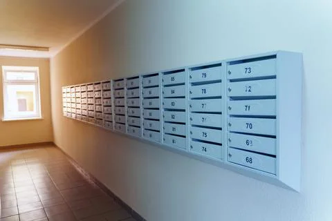 Rows of gray mailboxes with numbers in a residential building Stock Photos