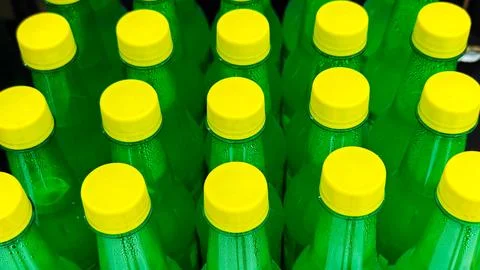 Rows of Green Plastic Bottles with Yellow Caps in Close Up Stock Photos