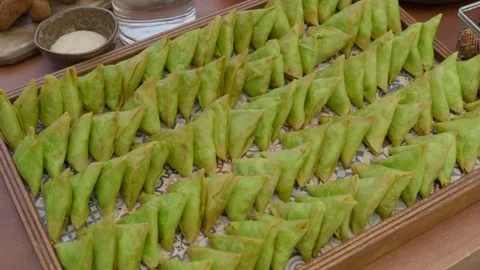 Rows of Green Samosas Arranged on Wooden Tray at Catering Buffet Table Stock Footage 343985345