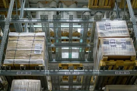 Rows of half empty shelves and pallets with boxes and products on it in mod.. Stock Photos
