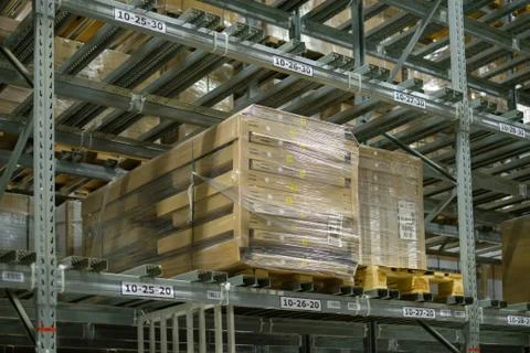 Rows of half empty shelves and pallets with boxes and products on it in mod.. Foto stock