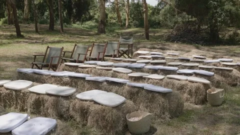 Rows of hay bales with white cushions and some wooden chairs await the Stock Footage 292265043