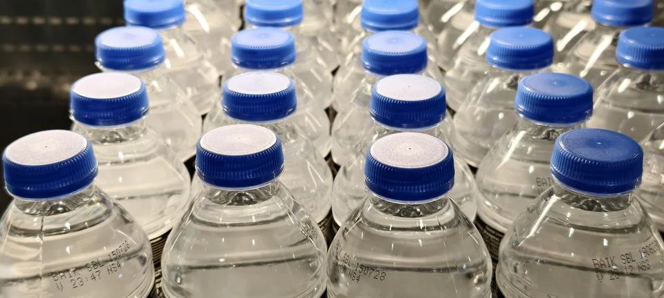 Rows of identical clear plastic water bottles Foto stock