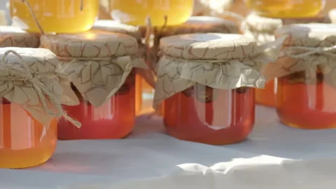 Rows of jars of bright yellow orange honey at the outdoor market Stock Footage 263625330