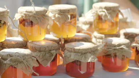 Rows of jars of bright yellow orange honey at the outdoor market Stock Footage 263625595