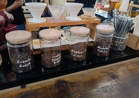 Rows of jars of coffee labeled with the name of the region of origin Stock Photos