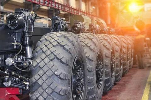 Rows of large tires ready for installation on military equipment highlight as Stock Photos