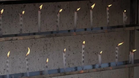Rows of lit prayer candles burning at Buddhist temple in Japan Stock Footage 337912936