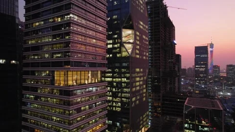 Rows of lit windows on glass office towers at dusk in Guangzhou China Stock Footage 346032795