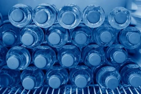 Rows of many transparent plastic bottles with drinking water supply in white Stock-Fotos
