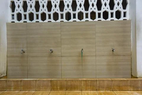 Rows of metallic water taps for ablution Stock Photos