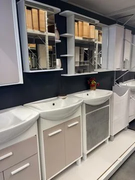 Rows of modern bathroom cabinets with sinks and mirrors on display in a fur.. Stock Photos