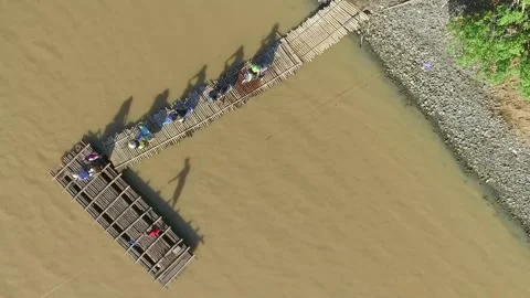 Rows of motorbikes using rafts to cross the river Stock Footage 158718069