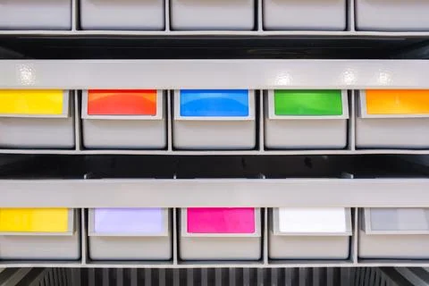 Rows of multicolored plastic boxes for components 库存照片