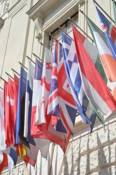 Rows of National Flags Mounted on Historic Building Stock Photos