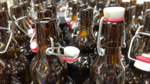 Rows of new brown glass bottles with swing top stoppers in a kitchenware store. Stock Footage 268111131