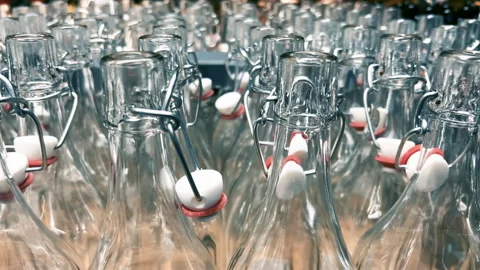Rows of new glass bottles with swing top stoppers in a kitchenware store. Stock Footage 266856647