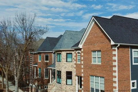 Rows of new homes feature brick exteriors and shingle roofs. The setting show Foto stock