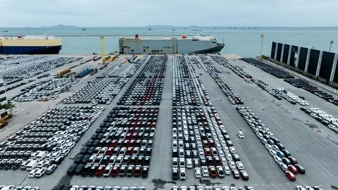 Rows Of New Vehicles Waiting For Export At A Busy Industrial Harbor High An.. Stock Photos
