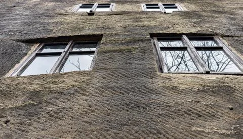 A rows of old windows in the stone facade of a historic house Stock Photos