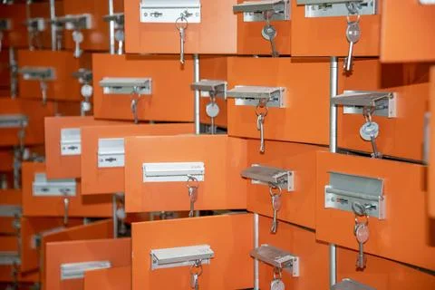 Rows of orange storage lockers with keys hanging in a facility during dayti.. Stock Photos