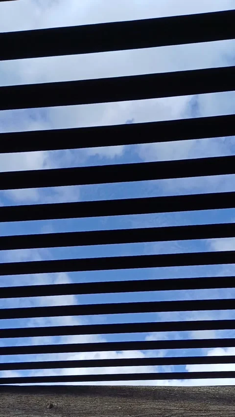 Rows of parallel porch canopy slats vibrating in the wind. Blue sky Stock-Footage 252373977