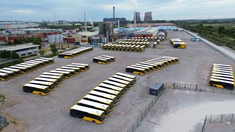 Rows of parked electric busses aerial view circling above large industrial site 库存影片 342412290